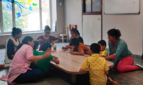Indian child sitting calmly in a quiet corner away from a busy family gathering, illustrating sensory overload management in autism