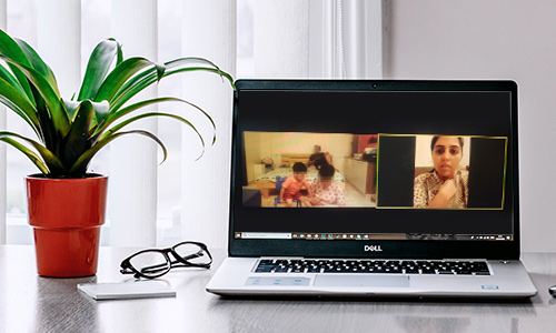 CRIA Foundation online therapy session shown on a laptop screen, parent and child seated together at home